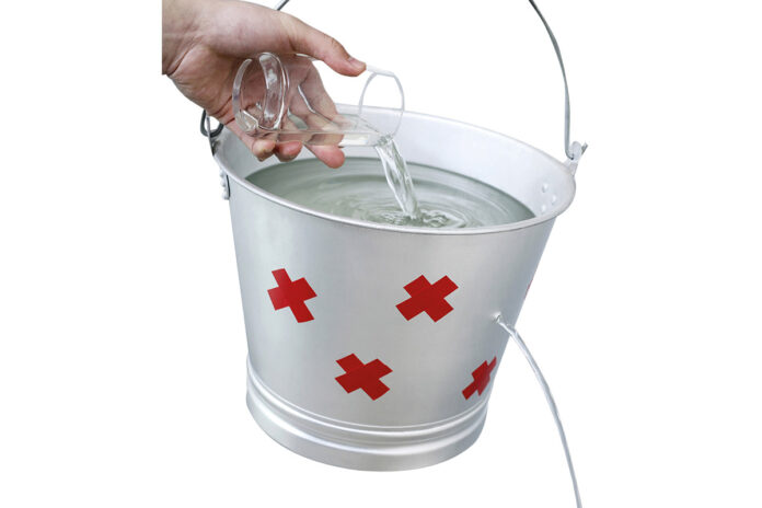 Hand pouring water from a glass into a leaking pail