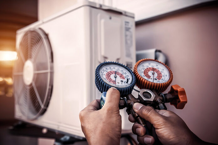 Air repair mechanic using measuring pressure gauge equipment for
